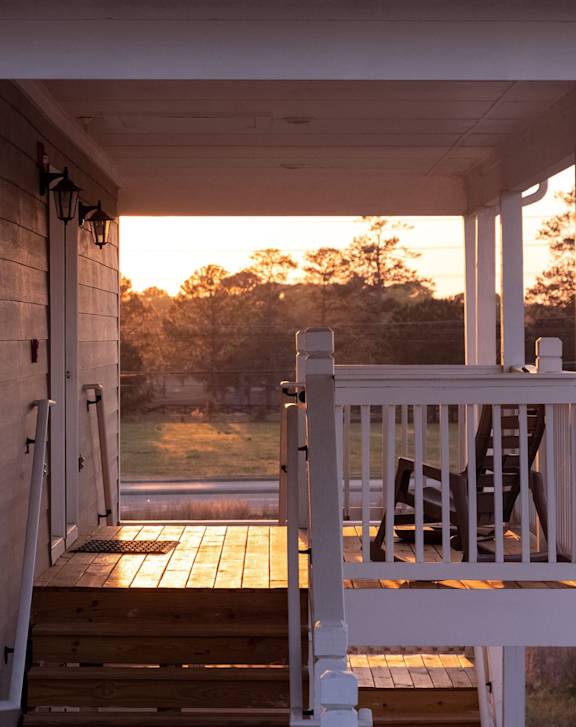 White porch with chair and a door leading to a grassy area at Club Villas Apartments, Kathleen, 31047