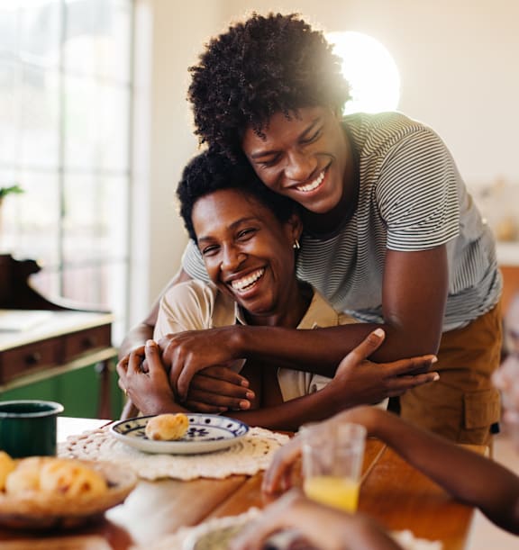 Two People Smiling while Hugging Each Other in Kitchen
