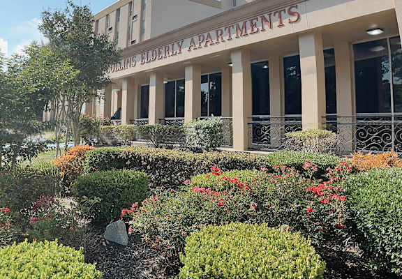 a picture of the front of the building with a garden in front of it