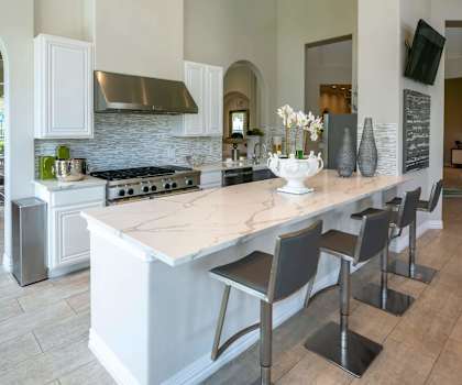 White Cabinetry And Appliances In Kitchen at Berkshire Woodland in Conroe, TX
