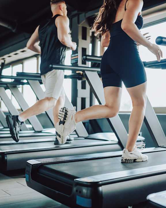 Man and Woman Running on Treadmill