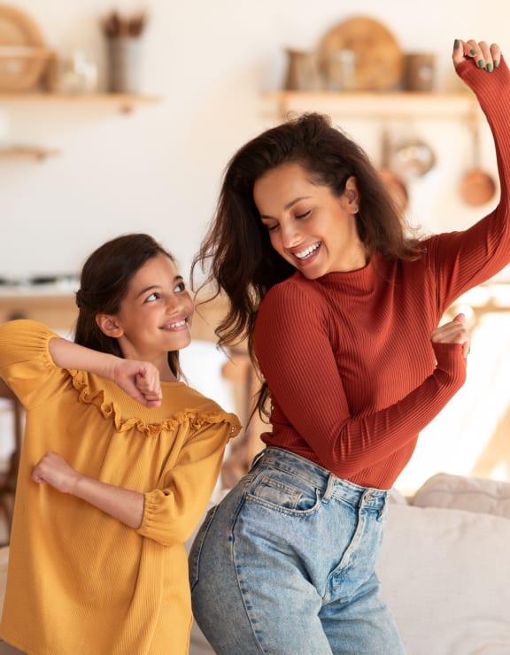 Woman and Girl Smiling while Dancing Together