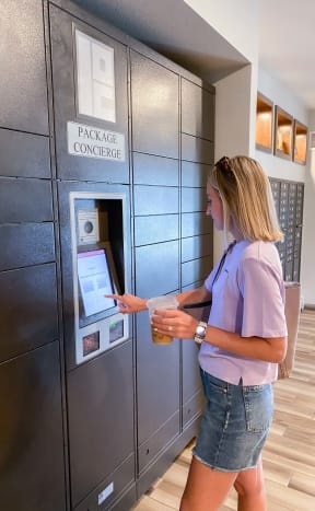 a woman getting her items from the package concierge in the lobby