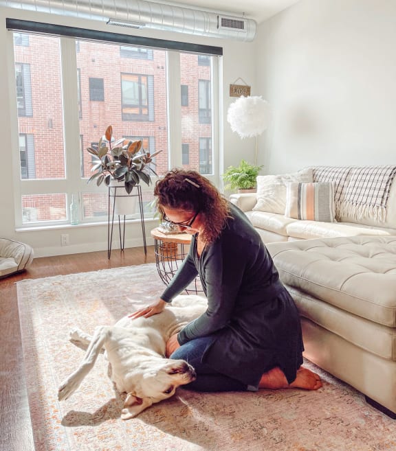 a woman is playing with her dog in a living room at Bluestone Flats, Minnesota, 55803