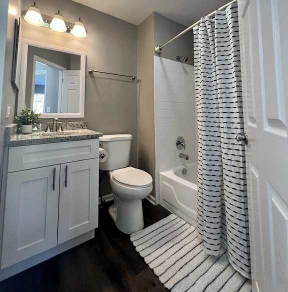 A white bathroom with a toilet, sink, and shower.
