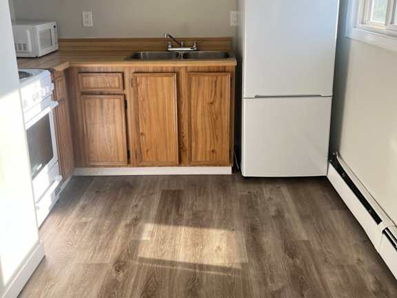A kitchen with wooden cabinets and a white refrigerator.
