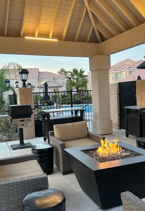 a patio with a fire pit and seating around it