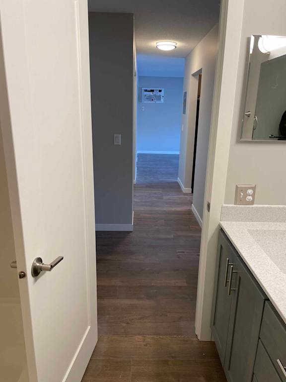 A hallway with a white door and a mirror on the wall.