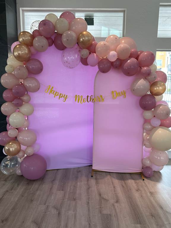 A balloon arch with the words "happy birthday" written on it.