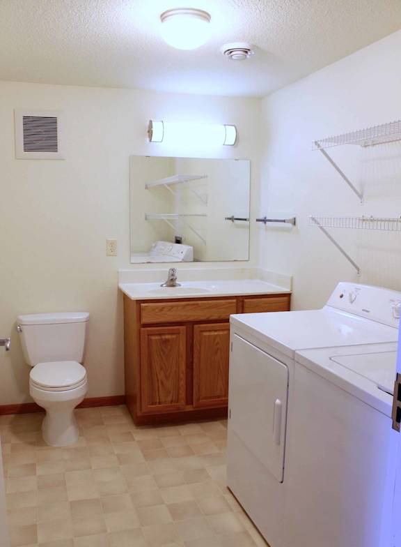 A white toilet sits next to a sink in a small bathroom.