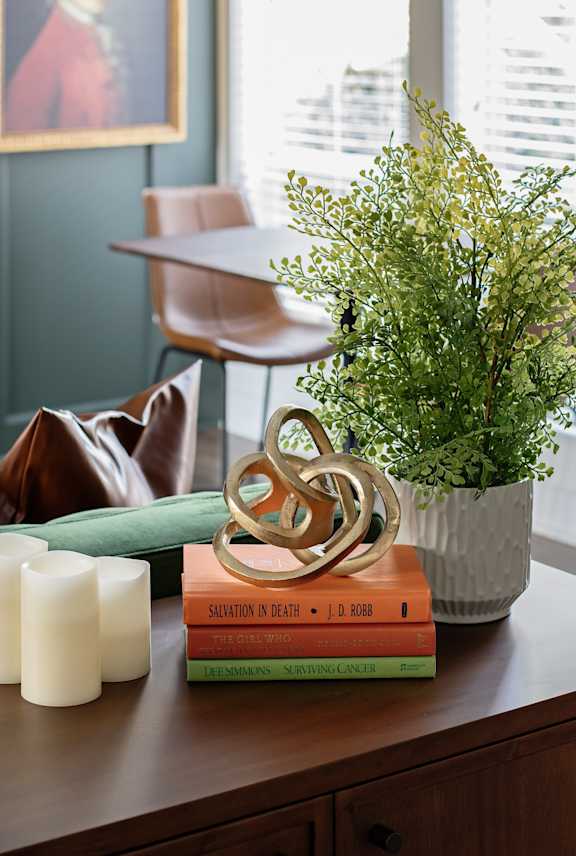 Books, Candles, and Plant on Wood Table