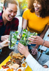 Friends Smiling while Having Drinks Together