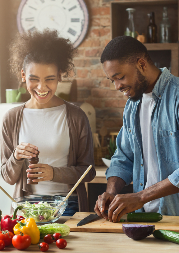a couple prepares a salad in their kitchen