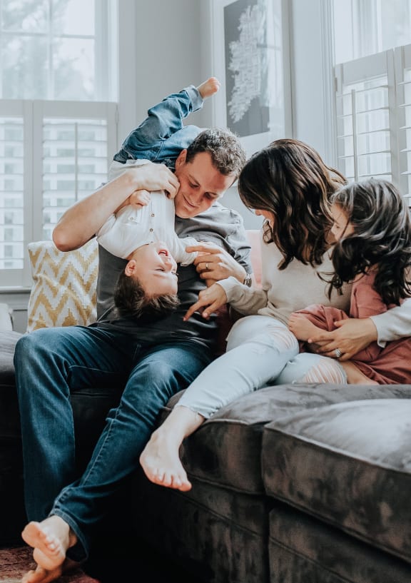 a documentary photograph of a family playing on the couch