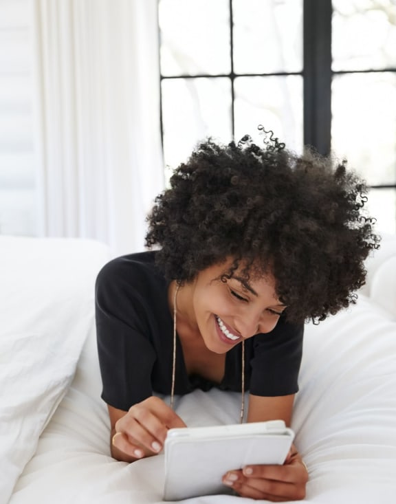 a woman reading while relaxing on a bed