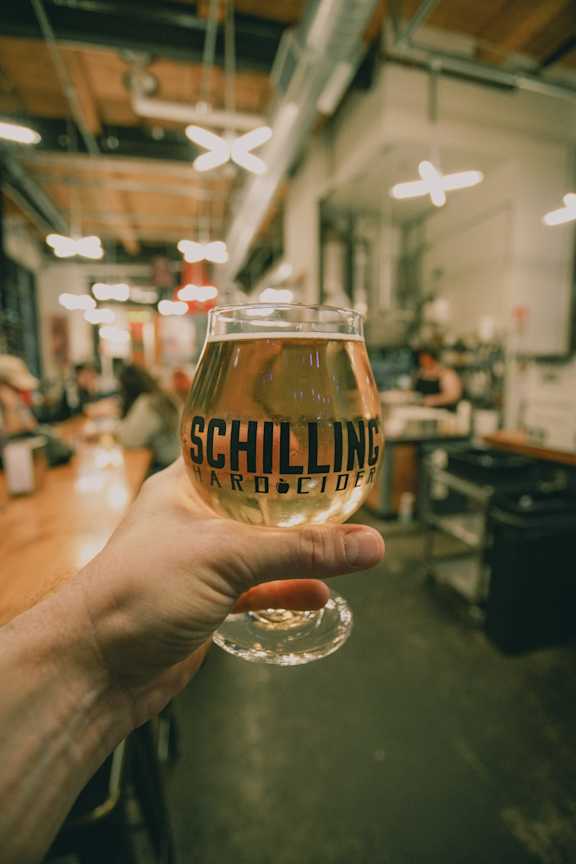 Man Holding Glass of Beer at Brewery
