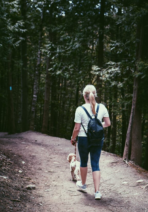 Woman Walking on Trail with Dog