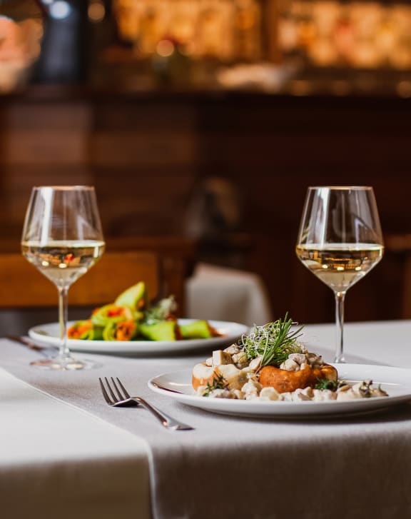 Plates of Food and Wine Glasses on Dinner Table