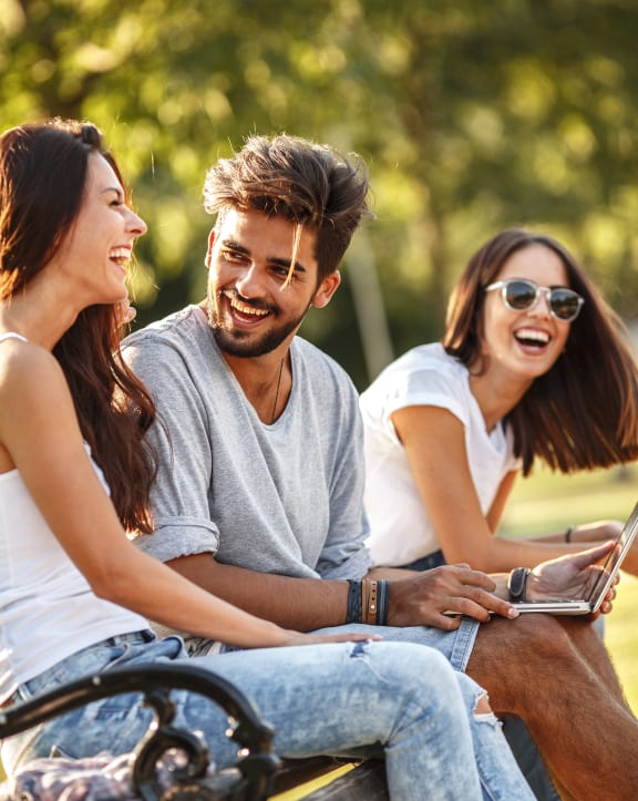 a group of people sitting on a bench in a park