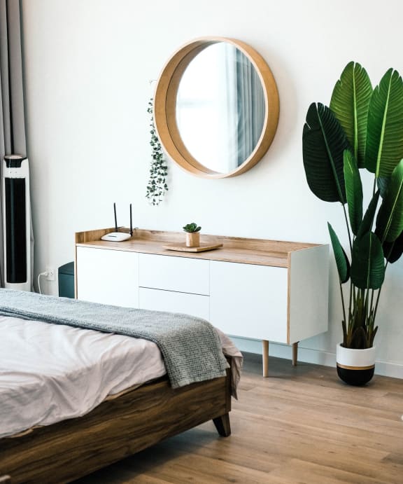 Model Bedroom with Plants and Large Mirror