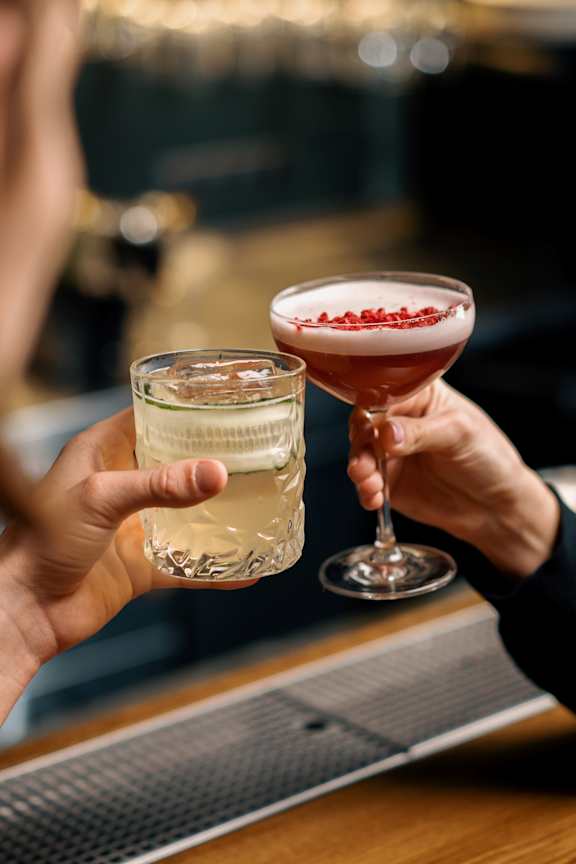 People Holding Cocktails and Toasting Together