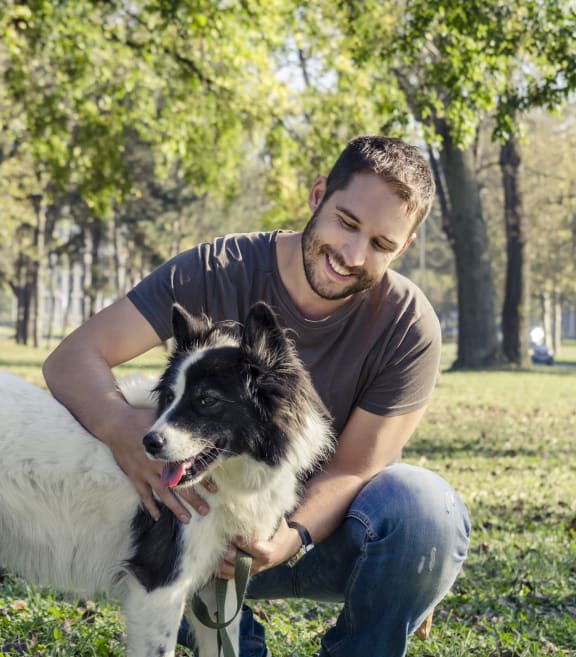 Man Smiling while at Park with Dog