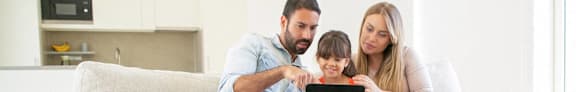 a family looking at a tablet in the living room