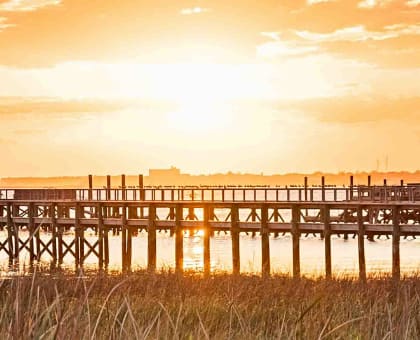 A boat is docked at the end of a pier.