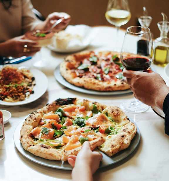 A group of people enjoying a meal together with wine.