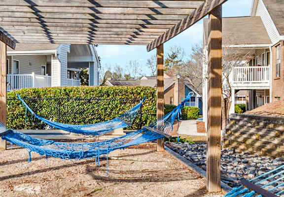 A blue hammock is strung between two wooden posts.
