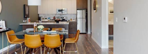 A kitchen with a table and chairs.