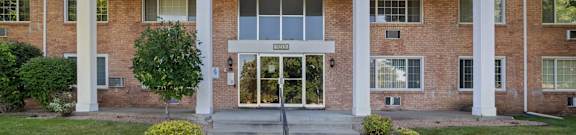 the front entrance of a brick building with glass doors