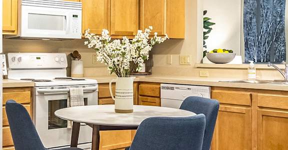 a kitchen with a table and chairs and a refrigerator