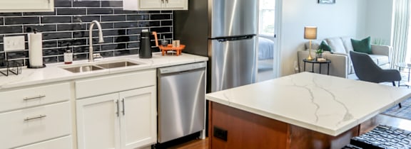 a cutting board with a plant and a vase on a kitchen counter