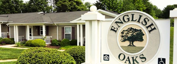 A sign that says English Oaks stands in front of a house at English Oaks Apartments, Fredericksburg