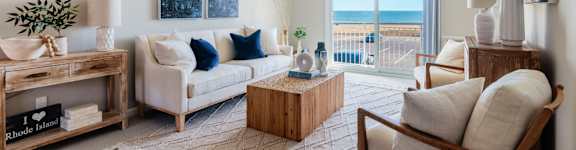 A living room with a white sofa and a wooden coffee table at 151 Ocean Road LLC, Narragansett
