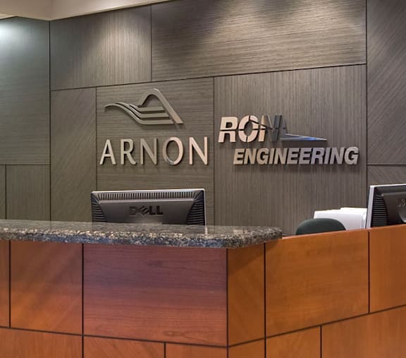 The reception desk of Arnon Engineering is made of wood and has a granite counter.
