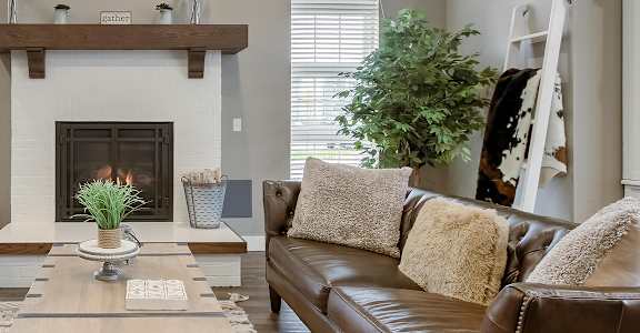 a living room with leather couches and a fireplace