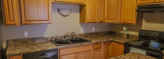 Omaha, NE Evergreen Terrace |a kitchen with granite counter tops and a sink