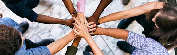 a group of people putting their hands together in a circle