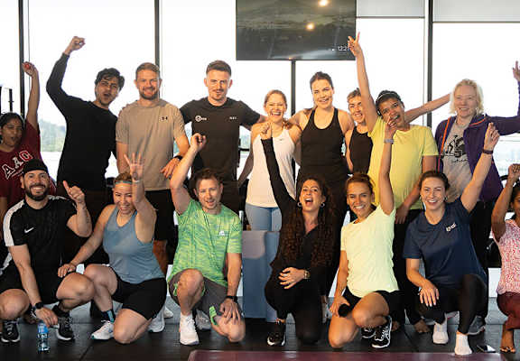 A group of people posing for a photo in a gym.
