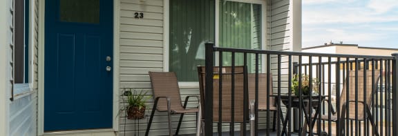 a porch with rocking chairs and a table