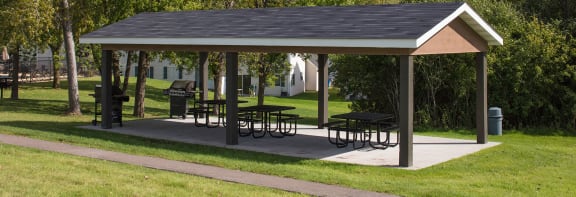 a pavilion with picnic tables in a park