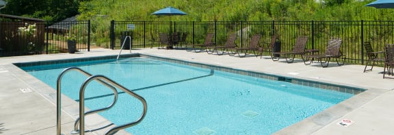 a swimming pool with chaise lounge chairs and umbrellas