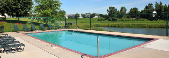 a swimming pool with a fence around it and a river in the background