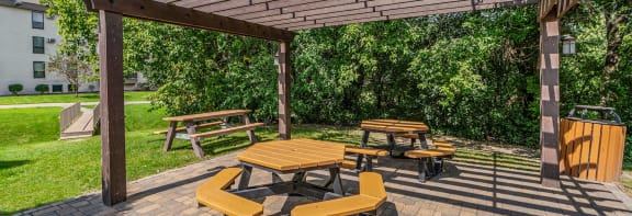 a patio with a pergola and a grill
