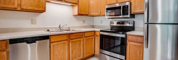 a kitchen with wooden cabinets and stainless steel appliances