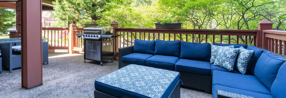 an outdoor patio with couches and a grill