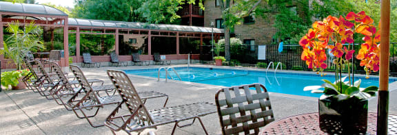 a swimming pool with chaise lounge chairs and a building in the background