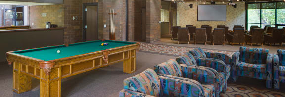 a large room with a pool table and chairs
